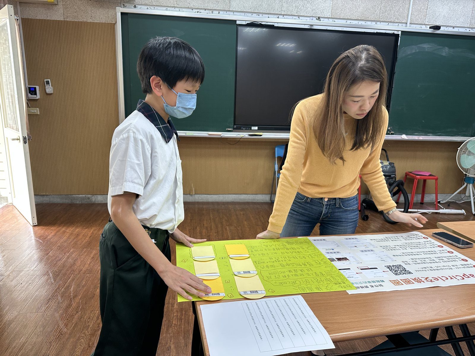 教師陪伴學生檢視作品內容
